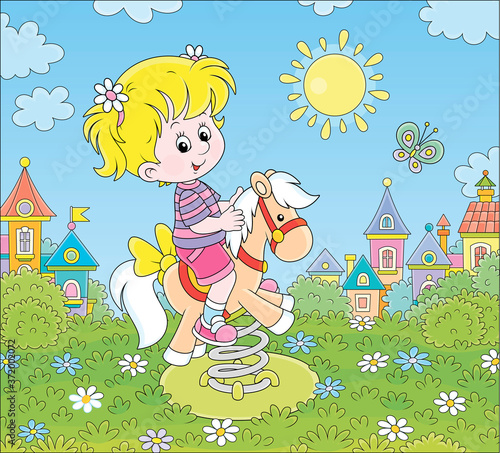 Smiling girl playing on a toy horse swing on a playground of a small town on a sunny summer day, vector cartoon illustration photo