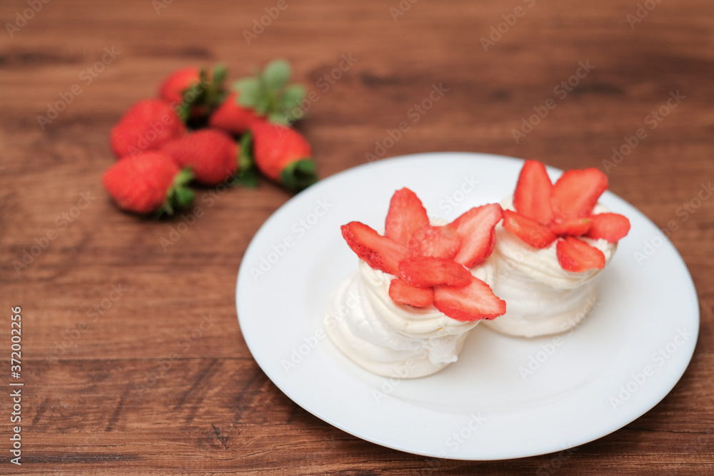 Mini pavlovas with whipped cream and fresh strawberry Mini pavlovas with whipped cream and fresh strawberry