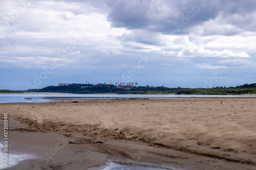 Sandy beach in cloudy weather. Bank of the river.