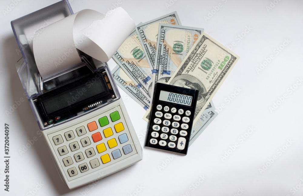 Top view of cash register with check tape, US dollars and calculator isolated on white background, flat lay, copy space Top view of cash register with check tape, US dollars and calculator isolated on white background, flat lay, copy space