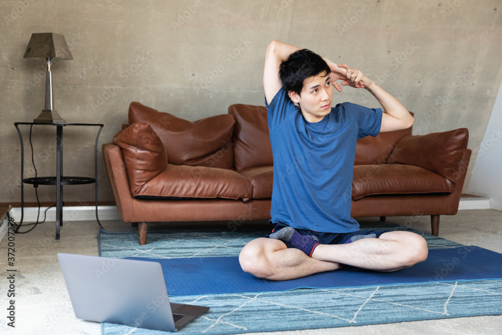 Man exercising at home in front of laptop Man exercising at home in front of laptop