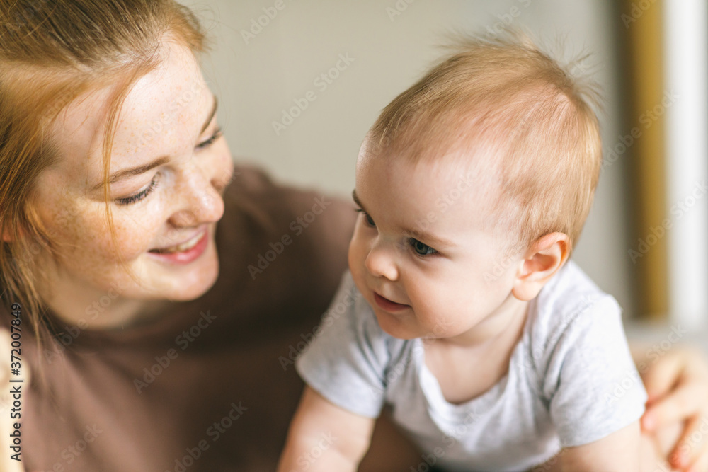 Mom hugs with her newborn baby in bed. Nine month old baby. Baby care, tenderness, motherhood Mom hugs with her newborn baby in bed. Nine month old baby. Baby care, tenderness, motherhood