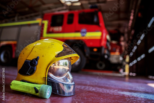 Closeup of protective helmet. In background is fire truck. Fire brigade interior.