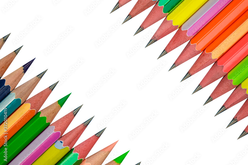 Fototapeta premium Bunch of row of different colored wood pencil crayons facing each other on white paper