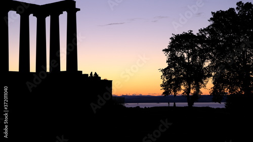 Summer Sunset photo of the National Monument of Scotland, with the moon in the background. Taken from Calton Hill in Edinburgh UK 