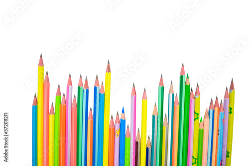 Long line of many different colored wood pencil crayons a white background