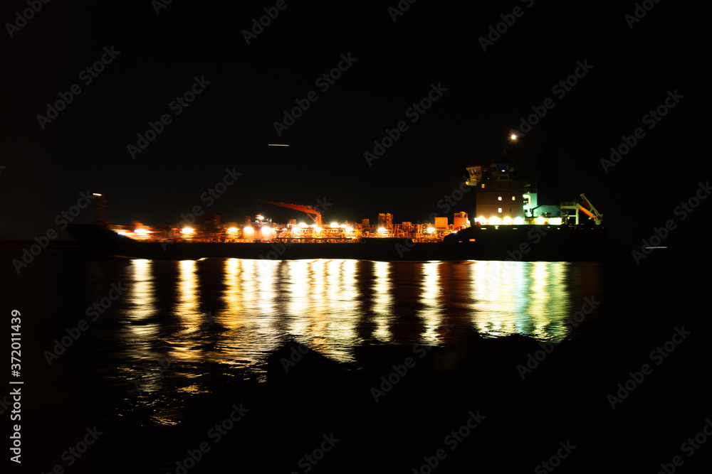 Ship passing by in the night while shooting panning shot