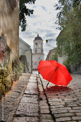 Fototapeta Naklejka Na Ścianę i Meble -  Red umbrella on an old european street