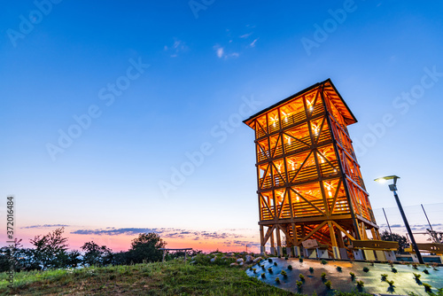 Fototapeta Naklejka Na Ścianę i Meble -  Wooden Lookout Tower in Dobrowka near tarnow in Poland. Illuminated at Sunrise. Tourist Attraction