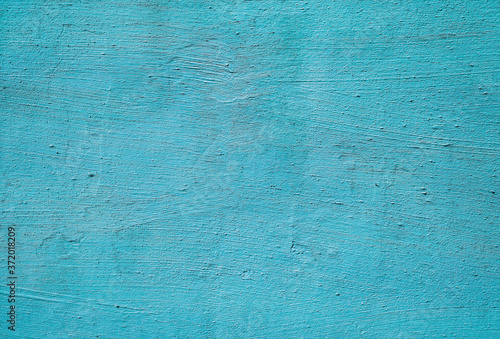 Texture of thick old blue paint on a plastered wall. Colored surface background.