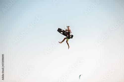 Fototapeta Naklejka Na Ścianę i Meble -  Kitesurfing Kiteboarding action photos man among waves quickly goes
