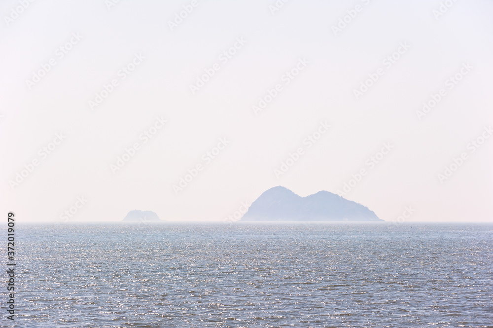 Misty island,mysterious seascape in light fog.