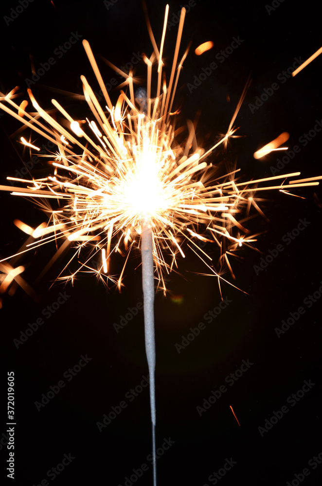 Blurred rays and sparks of sparkler on black background Blurred rays and sparks of sparkler on black background