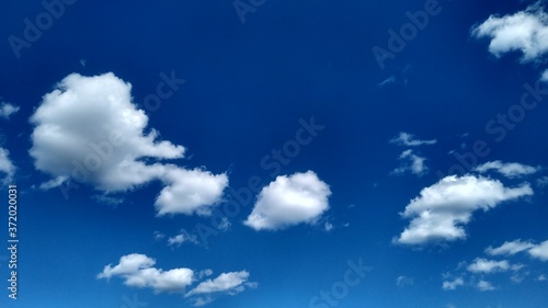 Blue sky with white clouds. Peaceful sky background. Space for text.