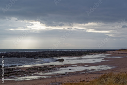 The empty beach at East Haven on the East Coast of Scotland, on a stormy, and cold day in February with the sand wet from the receding Tide.