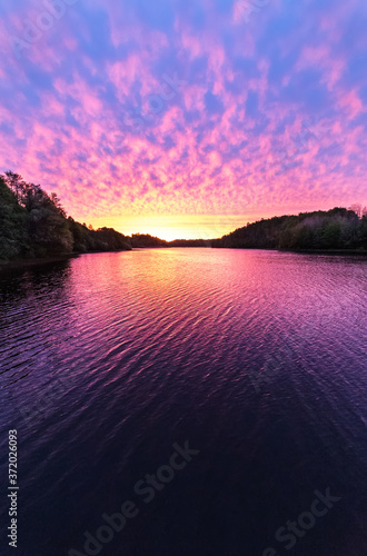 Pink summer sunrise over a lake.