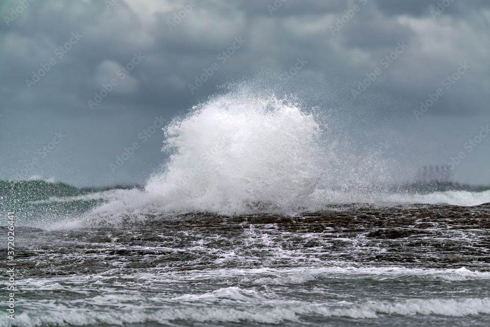 Waves breaking coastal rocks, selective focus