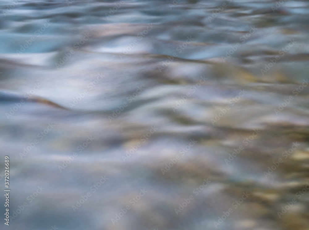 Long exposure picture of water stream flowing. Smooth water background texture.