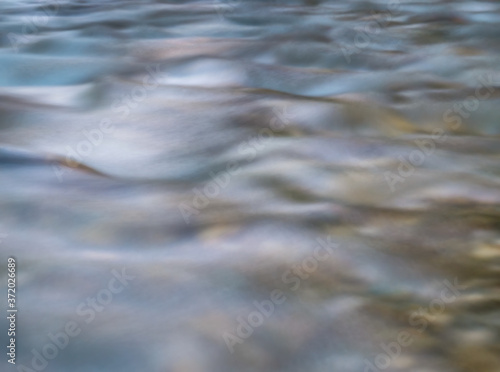 Long exposure picture of water stream flowing. Smooth water background texture. © Cristi