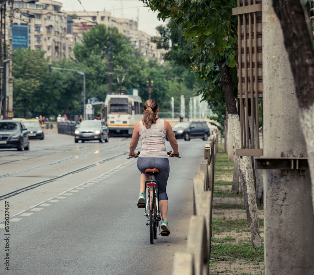 Girl ridding a bicycle on the streets of Bucharest.