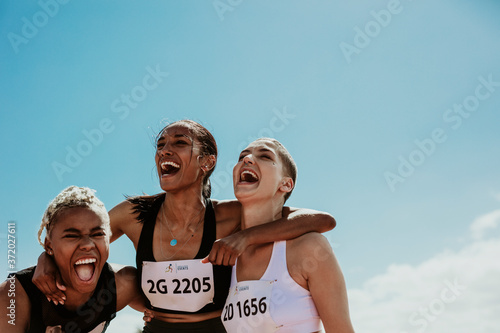 Group of female runners enjoying victory photo