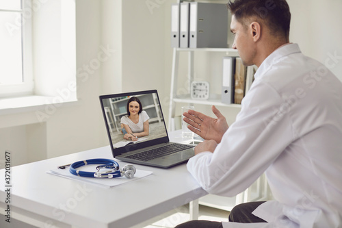 Doctor online. Young beautiful woman using video call and laptop to chat with doctors.