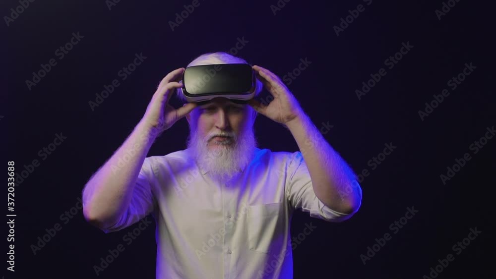 Video of an old albino grandfather putting on a new vr set and making different hand gestures, isolated on a cool background. Video of an old albino grandfather putting on a new vr set and making different hand gestures, isolated on a cool background.