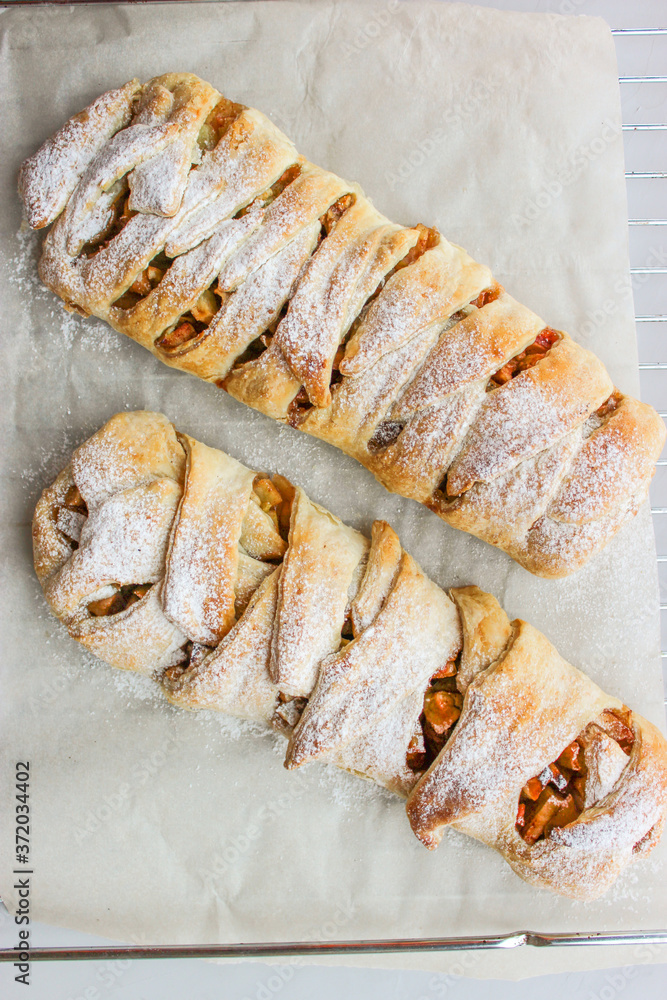 Φωτογραφία Apple strudel in the form of a pigtail from puff pastry
