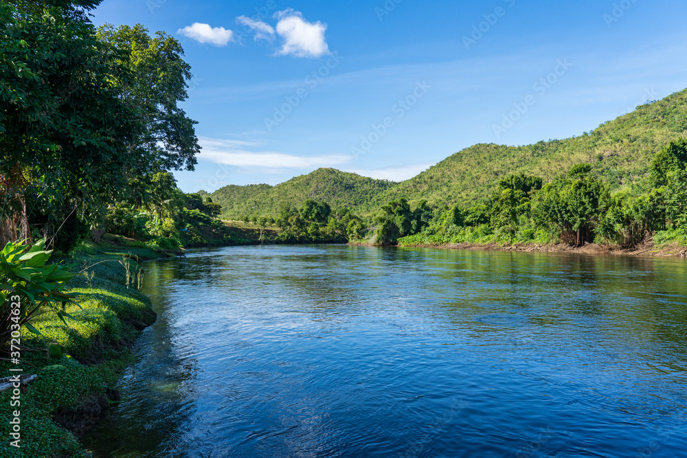 The clear stream flowing in the river reflects the blue sky. Flows through the mountains at the Kwai Yai River, Kanchanaburi, Thailand.