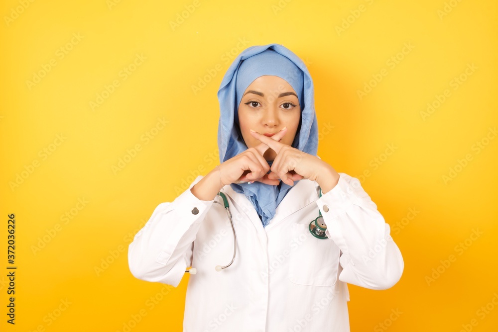 Φωτογραφία young beautiful Arab doctor woman wearing medical uniform standing over yellow background