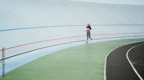 Handicapped athlete jogging on modern track. Fit woman training outdoors
