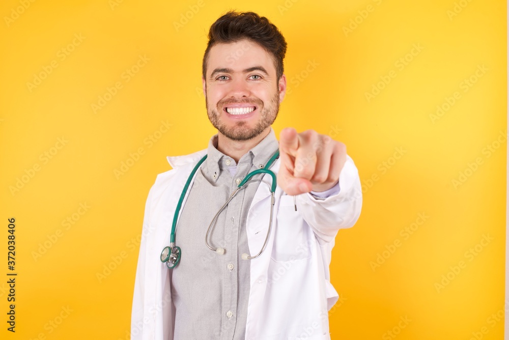 Young handsome Caucasian man pointing at camera with a satisfied, confident, friendly smile, choosing you against flat color wall Young handsome Caucasian man pointing at camera with a satisfied, confident, friendly smile, choosing you against flat color wall
