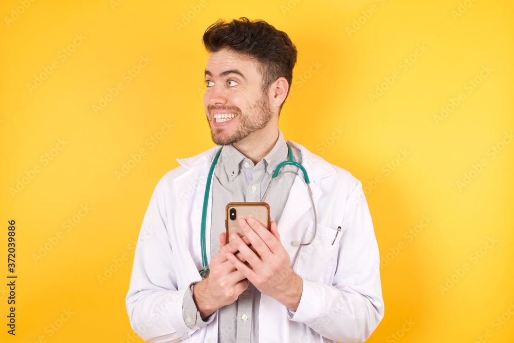 Copyspace photo of charming European doctor man wearing medical uniform, stupor with something occurring in social media wearing shirt isolated vivid color background Copyspace photo of charming European doctor man wearing medical uniform, stupor with something occurring in social media wearing shirt isolated vivid color background