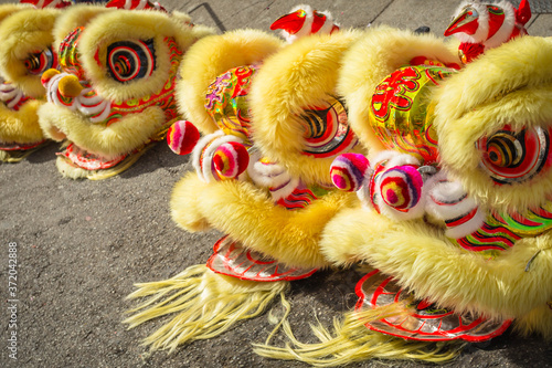 Chinese Yellow Dragon costume heads sitting in a row on the ground photo