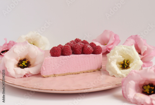 Raspberry cheesecake with berries and fresh flowers on pink plate food photo, sweet cake food photo art, kitchen, menu and restaurant photoshoot
