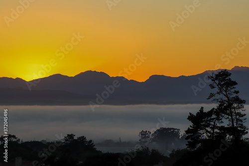 Sunrise in Cape Town from the Durbanville area showing mountain range and fog bank