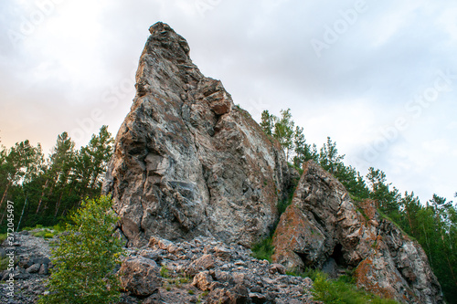 Steep picturesque rock with trees on top