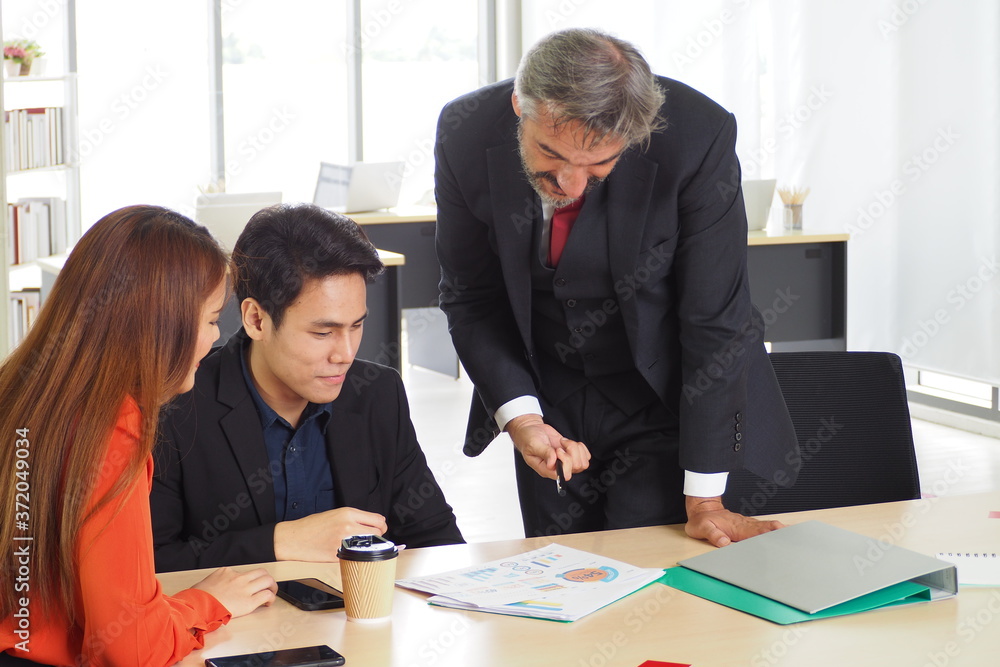 Senior male manager on the job training his colleague in the team for new project and work planning. Working lifestyle in the office and business people meeting concept