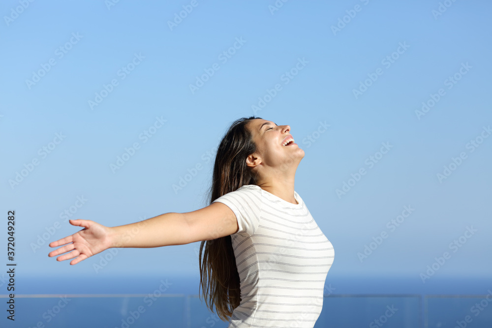 Happy woman breathing and stretching arms on the beach Happy woman breathing and stretching arms on the beach