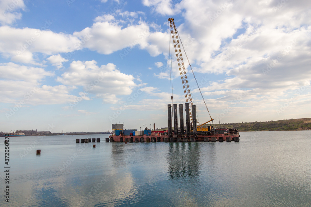  Construction of the berth from a metal sheet pile of the Larsen type, installation of piles of the berth wall with a floating crane..