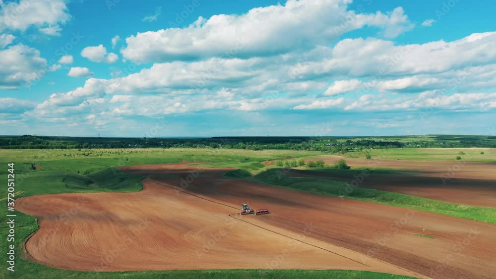 Agricultural tractor works on one field, plowing it for planting seeds. Agricultural tractor works on one field, plowing it for planting seeds.