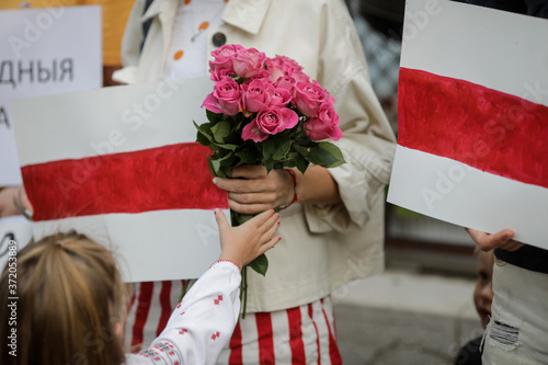 Details with a little girl holding flowers during a political rally supporting the protests in Belarus. photo