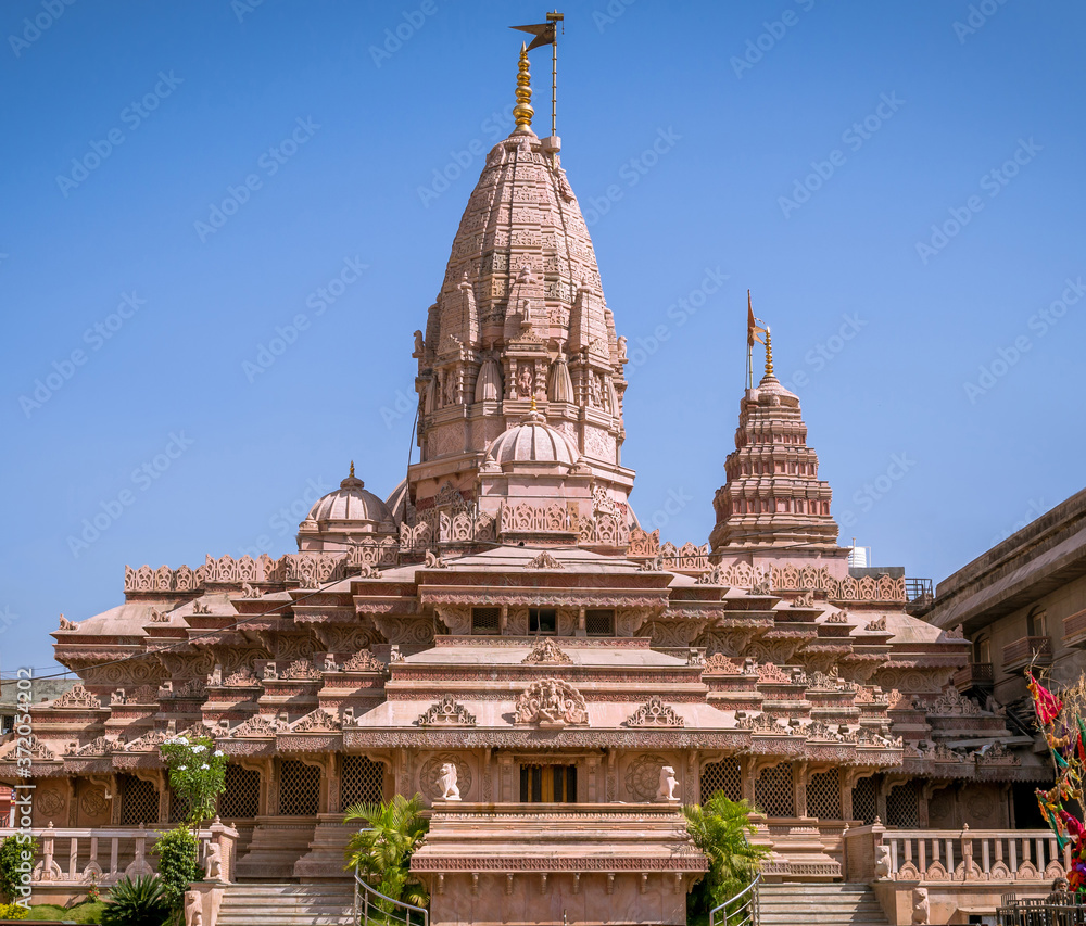 Nice carvings on goddess Ekveera temple with flag on clear blue sky background. Can be used as wallpaper background.