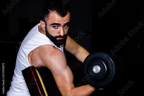 bodybuilder training with dumbbell in the gym