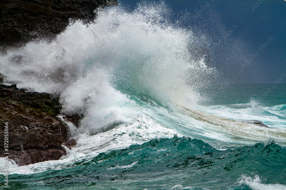 Fototapeta premium Waves crashing on the headlands on the north shore of Kauai, Hawaii.