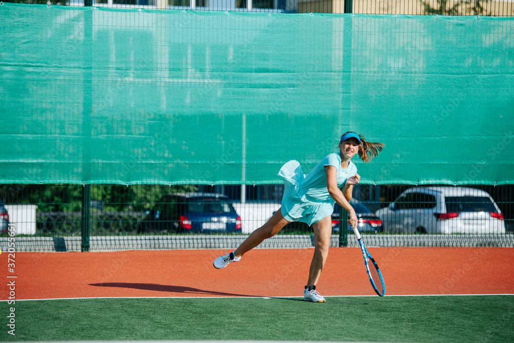 Powerful strike of a teenage girl training on a new tennis court
