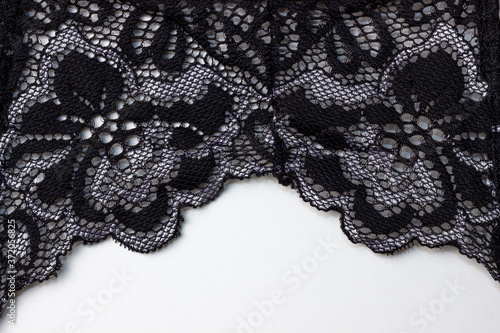 Black lace texture with flowers on a white background. Background of black lace with a flower pattern on a white background. Black guipure. Black fabric with an ornament.