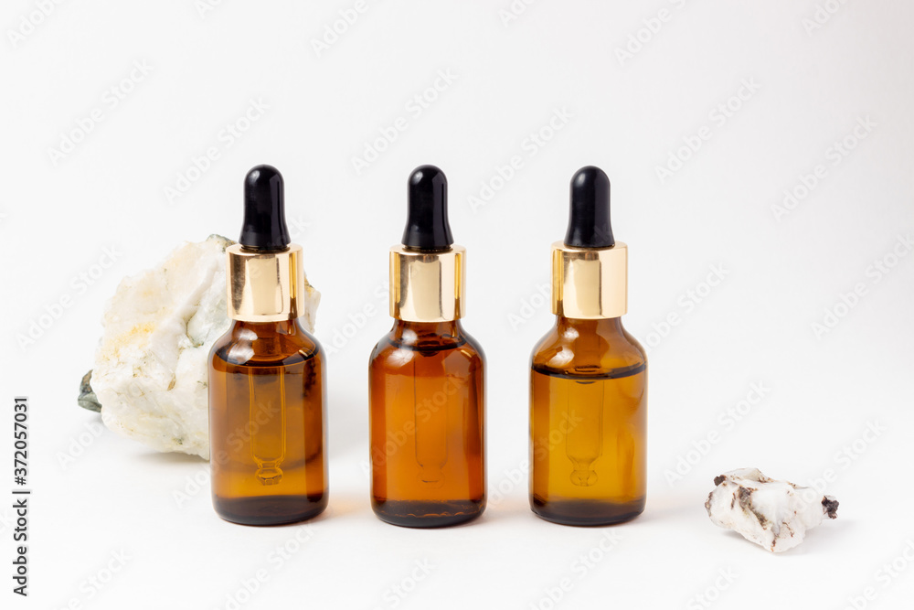 Amber Bottle for essential oils and cosmetic products. Glass bottle on white background. A dropper, a bottle with a sprayer
