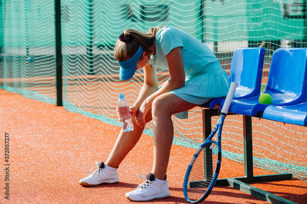Ταπετσαρία Tired teenage girl sitting on a chair bench next to tennis court to take a short