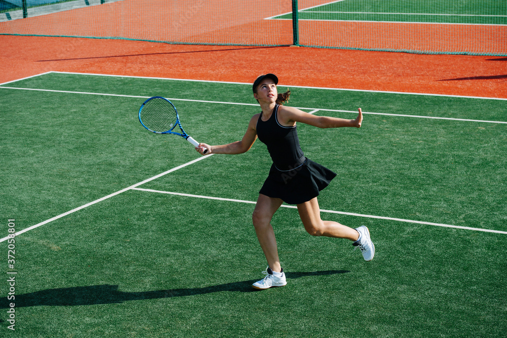Obraz premium Running teenage girl ready to return overhead tennis ball